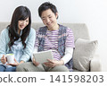 A couple watching a tablet on the sofa 141598203