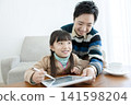 Parent and child watching a tablet in the living room 141598204
