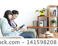A couple reading a book on the sofa 141598208