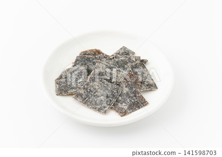 Pickled kelp on a plate against a white background. Pickled kelp on a plate against a white background. 141598703