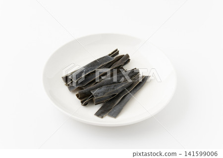 Chewing kelp on a plate against a white background. Chewing kelp on a plate against a white background. 141599006