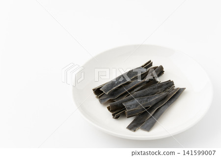 Chewing kelp on a plate against a white background. Chewing kelp on a plate against a white background. 141599007