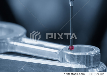 Ruby tip touch probe measuring automotive part precision in blue tone lighting Ruby tip touch probe measuring automotive part precision in blue tone lighting 141599404
