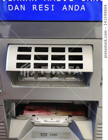 withdrawing money from an ATM withdrawing money from an ATM 141599804