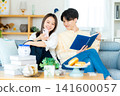 年輕夫婦在客廳裡看智能手機 141600057