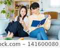 年輕夫婦在客廳裡看智能手機 141600080
