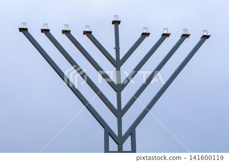 Jewish Hanukkiah candles shining against blue sky Jewish Hanukkiah candles shining against blue sky 141600119