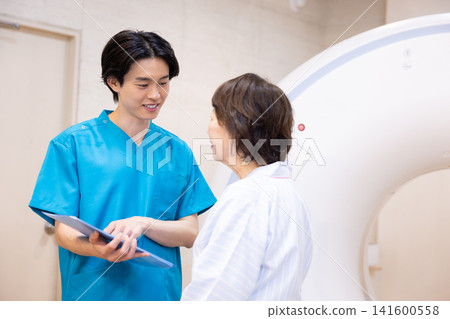 患者正在接受CT掃描,放射科醫師也在場。照片由東京電子大學電波學園教育基金會提供。 患者正在接受CT掃描,放射科醫師也在場。照片由東京電子大學電波學園教育基金會提供。 141600558