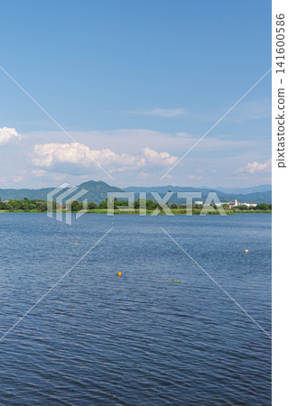 A wide river and mountains towering in the distance. A wide river and mountains towering in the distance. 141600586