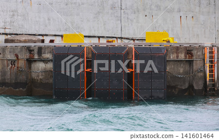 Black rubber fender panels mounted on a concrete pier protect vessels from impact Black rubber fender panels mounted on a concrete pier protect vessels from impact 141601464