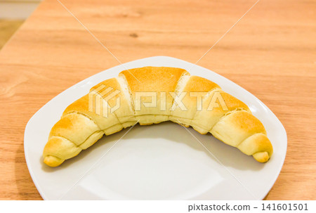 A traditional Hungarian bread, Kifli, served on a wood-grained table and plate. A traditional Hungarian bread, Kifli, served on a wood-grained table and plate. 141601501