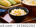 Corn rice, a summer mixed rice dish served in a wooden rice container and a bowl. 141602202
