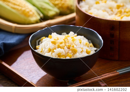 Corn rice, a summer mixed rice dish served in a wooden rice container and a bowl. Corn rice, a summer mixed rice dish served in a wooden rice container and a bowl. 141602202