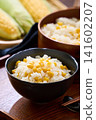 Corn rice, a summer mixed rice dish served in a wooden rice container and a bowl. 141602207