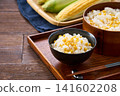 Corn rice, a summer mixed rice dish served in a wooden rice container and a bowl. 141602208