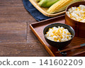 Corn rice, a summer mixed rice dish served in a wooden rice container and a bowl. 141602209