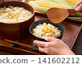 Corn rice, a summer mixed rice dish served in a wooden rice container and a bowl. 141602212