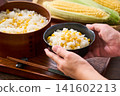 Corn rice, a summer mixed rice dish served in a wooden rice container and a bowl. 141602213