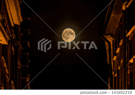 Stunning Full Moon Illuminates Dark Sky Between Silhouettes of Historic Buildings in a Mystical Night Scene. Ghent town in Belgium, Europe. Stunning Full Moon Illuminates Dark Sky Between Silhouettes of Historic Buildings in a Mystical Night Scene. Ghent town in Belgium, Europe. 141602259