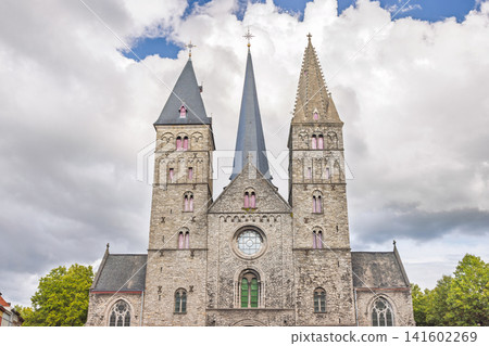Ghent town in Belgium, Europe. Historical Stone Church with Multiple Spires and Gothic Architecture Against a Cloudy Sky on a Bright Day Ghent town in Belgium, Europe. Historical Stone Church with Multiple Spires and Gothic Architecture Against a Cloudy Sky on a Bright Day 141602269