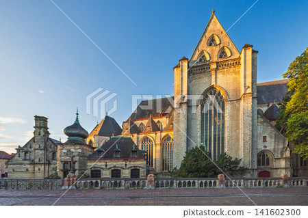 Ghent town in Belgium, Europe. Saint Michael's Church. Architecture at Golden Hour: Historic Stone Building, Ornate Features, and Clear Blue Sky Displaying Timeless Beauty Ghent town in Belgium, Europe. Saint Michael's Church. Architecture at Golden Hour: Historic Stone Building, Ornate Features, and Clear Blue Sky Displaying Timeless Beauty 141602300