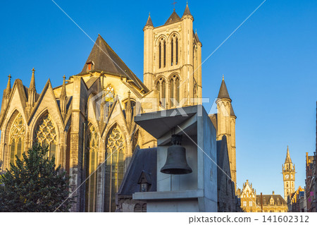 Saint Nicholas' Church in Ghent town in Belgium, Europe. Historic Cathedral and Bell Tower Against a Clear Blue Sky: Medieval Architecture in European City during Golden Hour 141602312