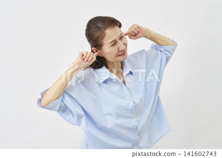 Elderly woman covering her ears on a white background Elderly woman covering her ears on a white background 141602743