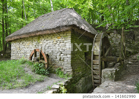 Old stone water mill surrounded by green trees Old stone water mill surrounded by green trees 141602990