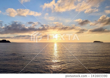 A breathtaking view of the tranquil Sea of Japan against a backdrop of a golden sunset. A breathtaking view of the tranquil Sea of Japan against a backdrop of a golden sunset. 141603390