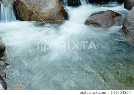 清澈的溪水潺潺流過岩石,景色優美。 清澈的溪水潺潺流過岩石,景色優美。 141603504