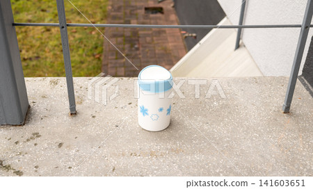 Small decorative trash bin on balcony with blue floral design Small decorative trash bin on balcony with blue floral design 141603651