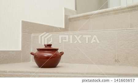Brown ceramic pot on beige tiled staircase corner 141603657