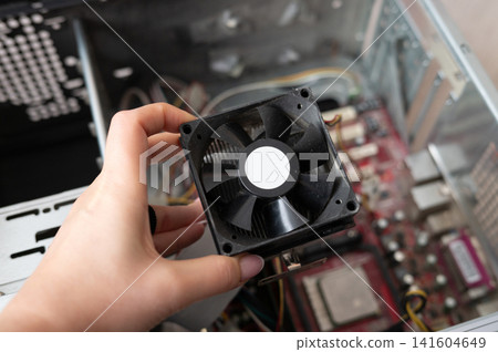 Hand installing cpu cooler in open computer case for effective heat management Hand installing cpu cooler in open computer case for effective heat management 141604649