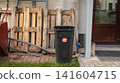 Outdoor recycling bin and wooden pallets near residential entrance 141604715