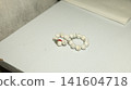 Minimalist white and red beaded bracelets on tabletop 141604718