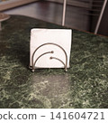 Elegant silver napkin holder on green marble table in modern dining room 141604721