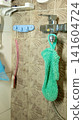 Shower interior with green scrubbing glove and vintage tile design 141604724