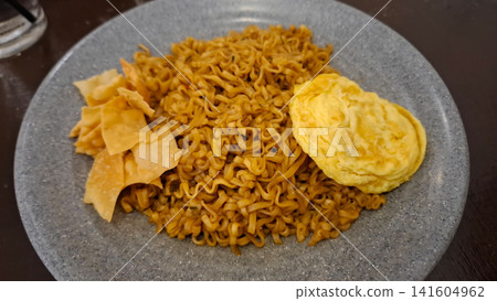 Indonesian Spicy Fried Noodles Served with Fried Egg and Crispy Chips Indonesian Spicy Fried Noodles Served with Fried Egg and Crispy Chips 141604962