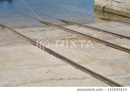 Boat slipway rails leading into the sea water Boat slipway rails leading into the sea water 141605614