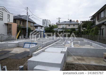 在安靜的住宅區,一棟獨立式房屋正在進行地基施工,現場設有臨時廁所。 在安靜的住宅區,一棟獨立式房屋正在進行地基施工,現場設有臨時廁所。 141605767