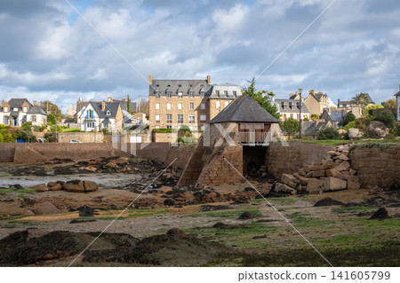 Historic tidal mill surrounded by granite houses in Tregastel, Brittany, France 141605799