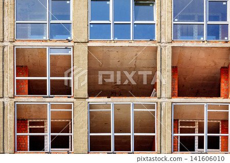 Construction of building with empty windows and visible brickwork in an urban setting. 04.10.2019. Kyiv. Ukraine Construction of building with empty windows and visible brickwork in an urban setting. 04.10.2019. Kyiv. Ukraine 141606010