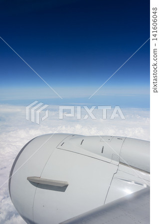 A view of the blue sky and sea of clouds from an airplane window – an image of air travel. A view of the blue sky and sea of clouds from an airplane window – an image of air travel. 141606048