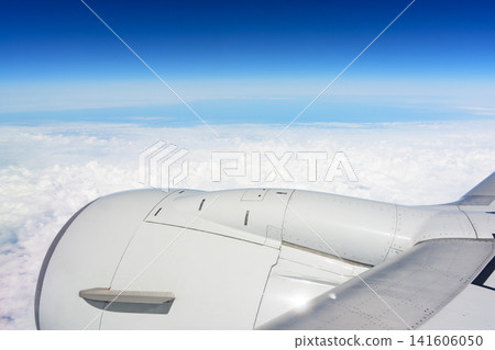 A view of the blue sky and sea of clouds from an airplane window – an image of air travel. A view of the blue sky and sea of clouds from an airplane window – an image of air travel. 141606050