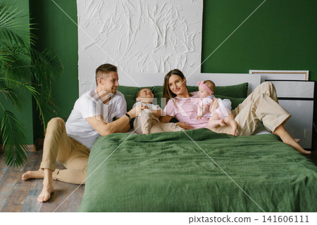Happy Family With Children Relaxing On Bed Happy Family With Children Relaxing On Bed 141606111