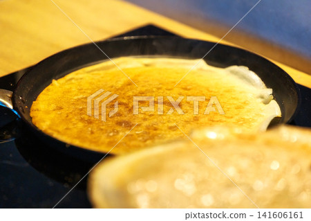 Close up of thin crepe frying in pan Close up of thin crepe frying in pan 141606161
