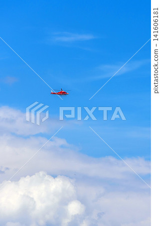 red medical rescue helicopter flying high in the blue sky, copy space 141606181