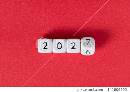 Year 2026 changing to 2027 on dice, glitter festive red background. New year change concept Year 2026 changing to 2027 on dice, glitter festive red background. New year change concept 141606203