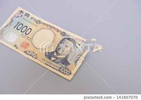 一張被貓啃咬損壞的1000日元鈔票。 一張被貓啃咬損壞的1000日元鈔票。 141607070