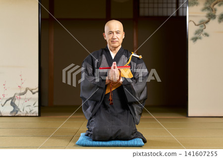 Portrait of a Buddhist priest sitting in a seiza (kneeling) position in a Japanese-style room. Portrait of a Buddhist priest sitting in a seiza (kneeling) position in a Japanese-style room. 141607255